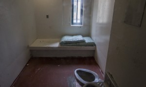 interior empty prison cell with mattress
